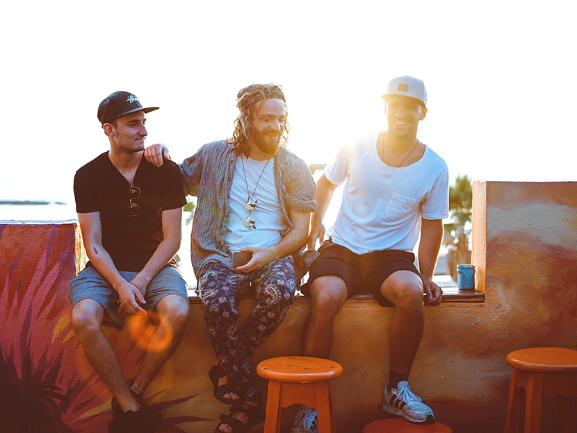 Three male friends sitting together, having a good time